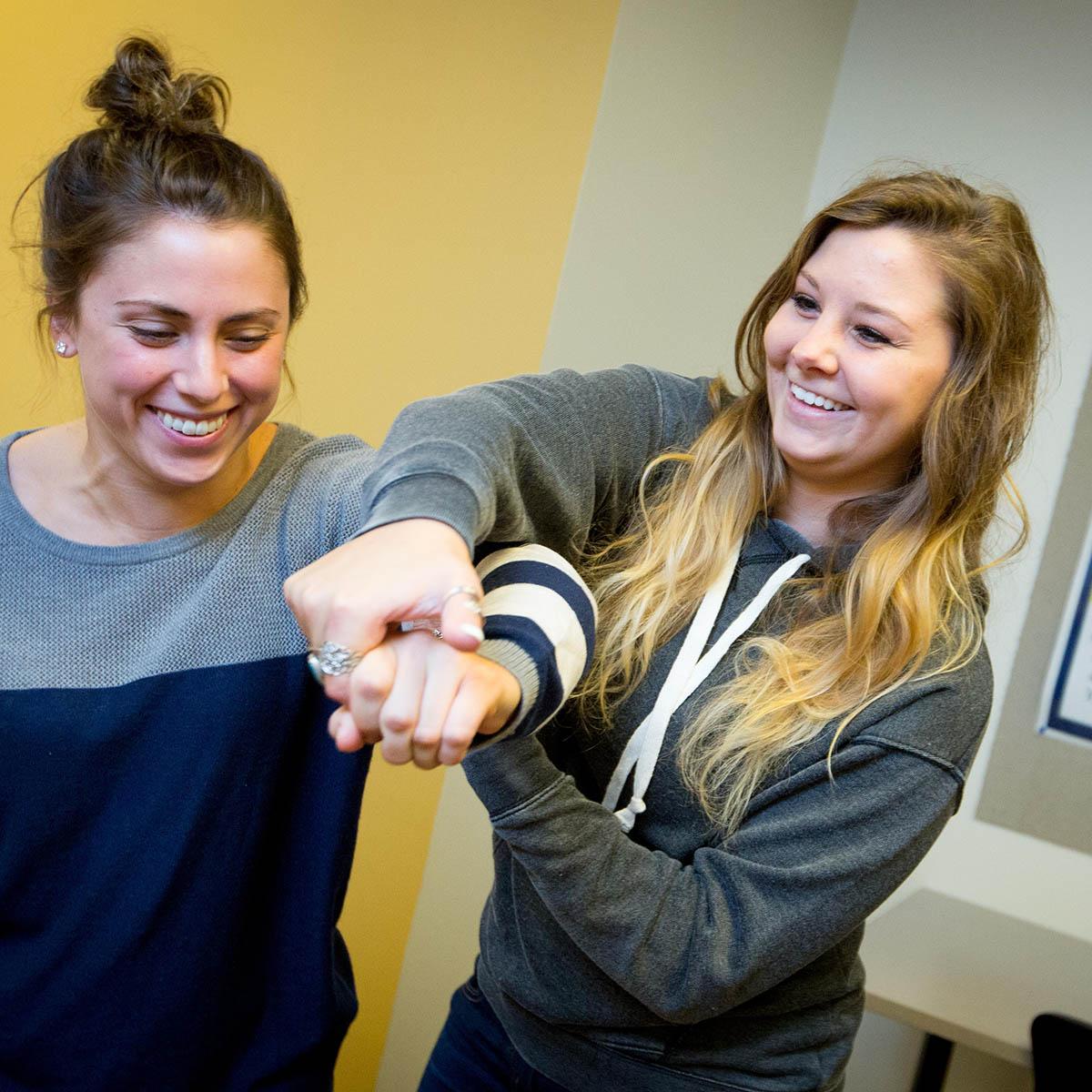 Photo of two occupational therapy 学生 smiling and working together